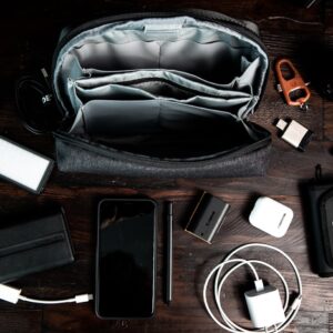 A flat lay of various electronic gadgets and accessories arranged neatly on a dark wooden surface.